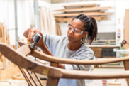 jeune fille réalisant des gestes professionnels de menuiserie-ébénisterie.